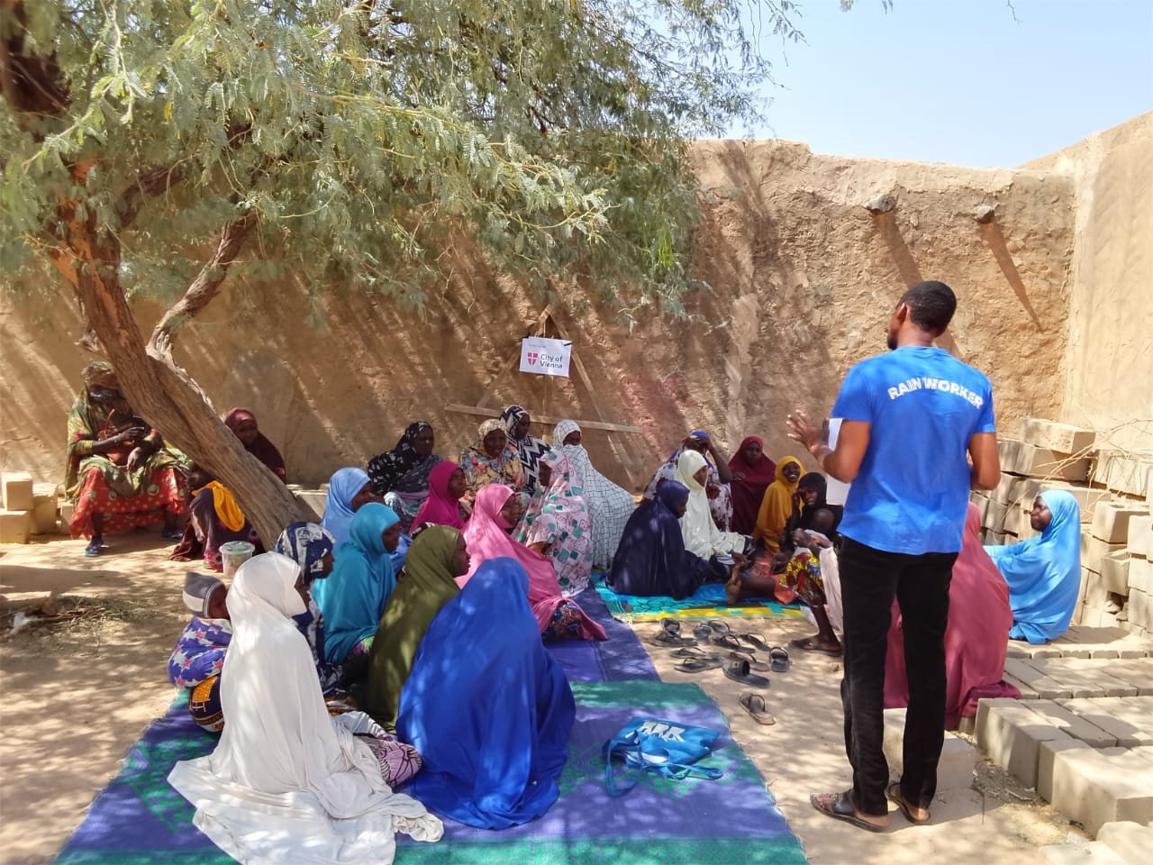 RAIN WORKER im Gespräch mit Frauen in Niger bei einem TREETING also einem Community-Meeting unter einem Baum im Niger.